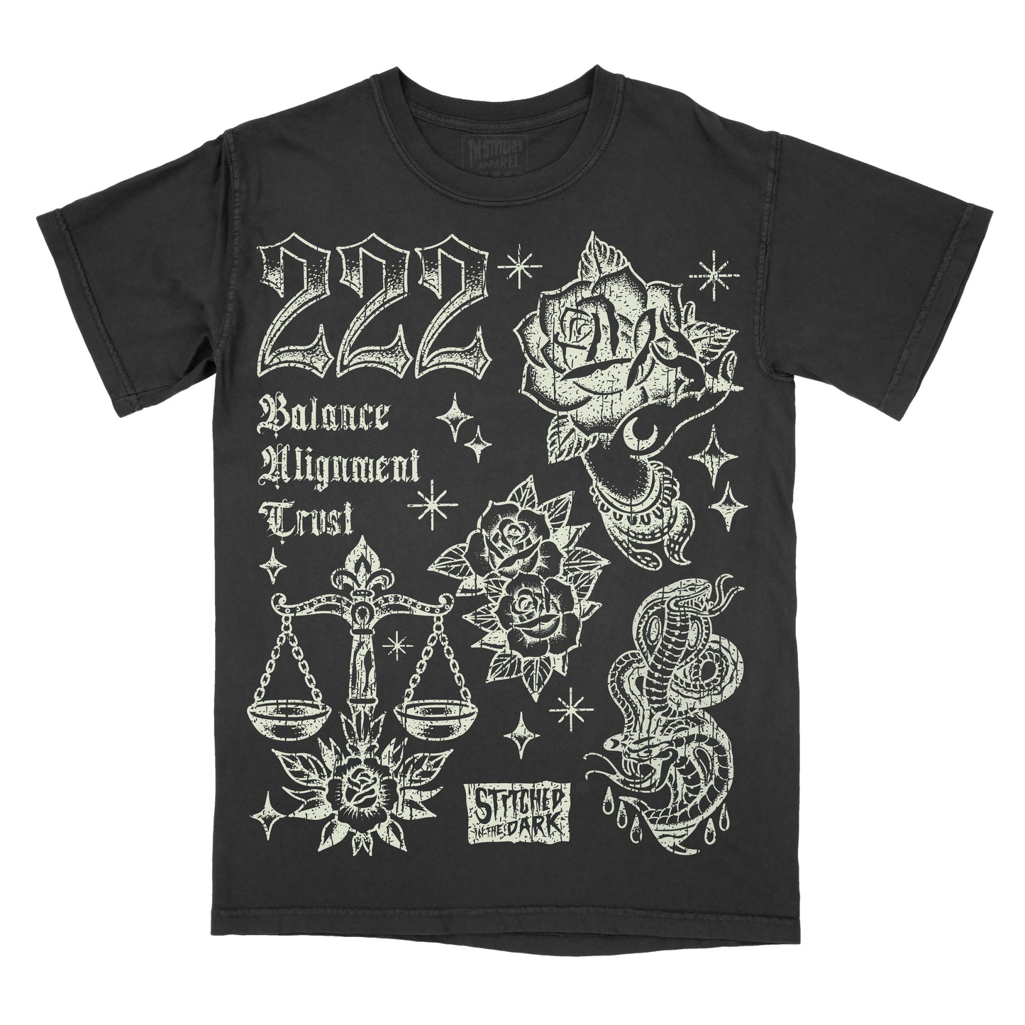 black T-shirt featuring a distressed 222 angel number design with roses, a mystical hand, balance scales, snakes, and stars, with text reading “Balance,” “Alignment,” and “Trust,” plus Stitched in the Dark branding.