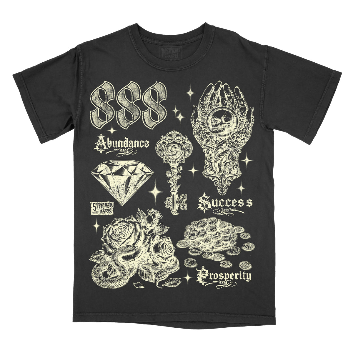 black T-shirt featuring a distressed 888 angel number design with a diamond, ornate key, mystical hand holding a skull, roses, snake, and coins, with text reading “Abundance,” “Success,” and “Prosperity,” plus Stitched in the Dark branding.