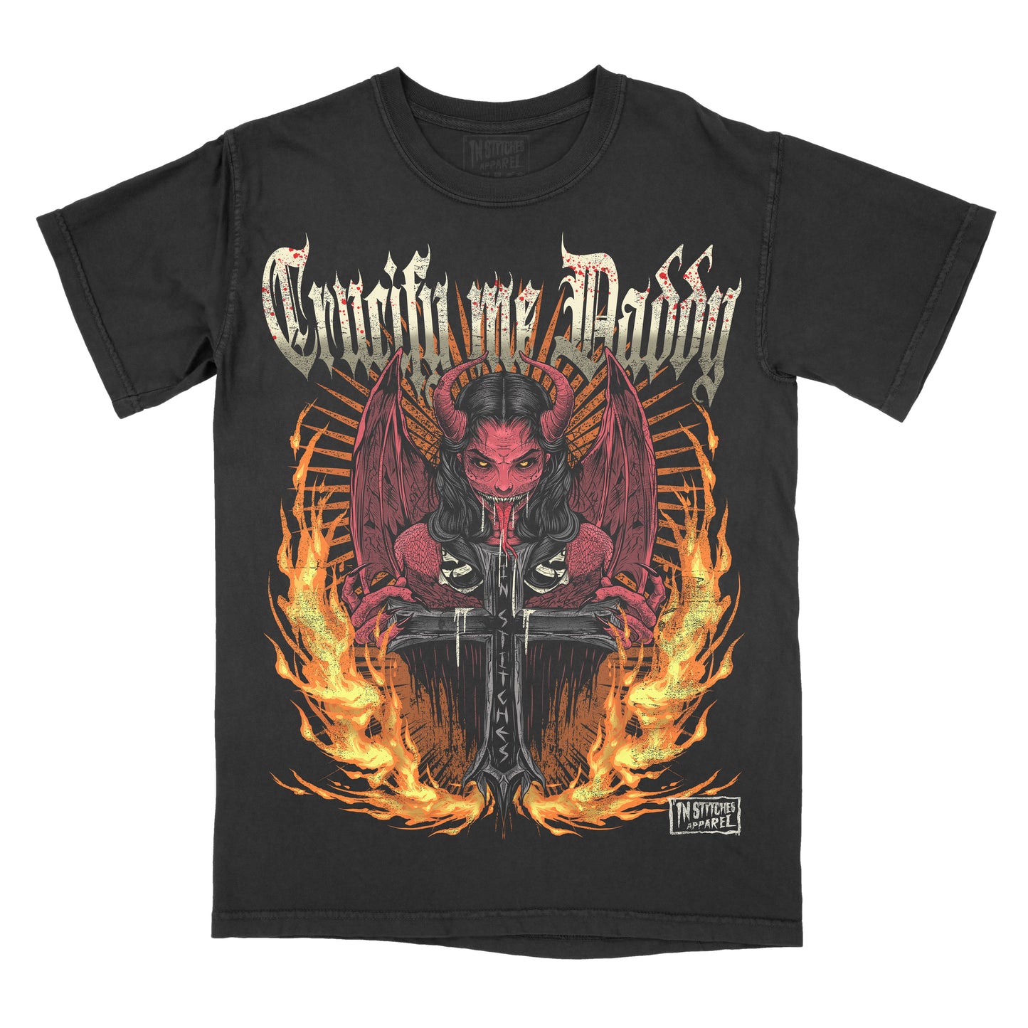 Black t-shirt with a graphic design of a demon holding a cross and flames with the phrase crucify me daddy across the chest on a white background.