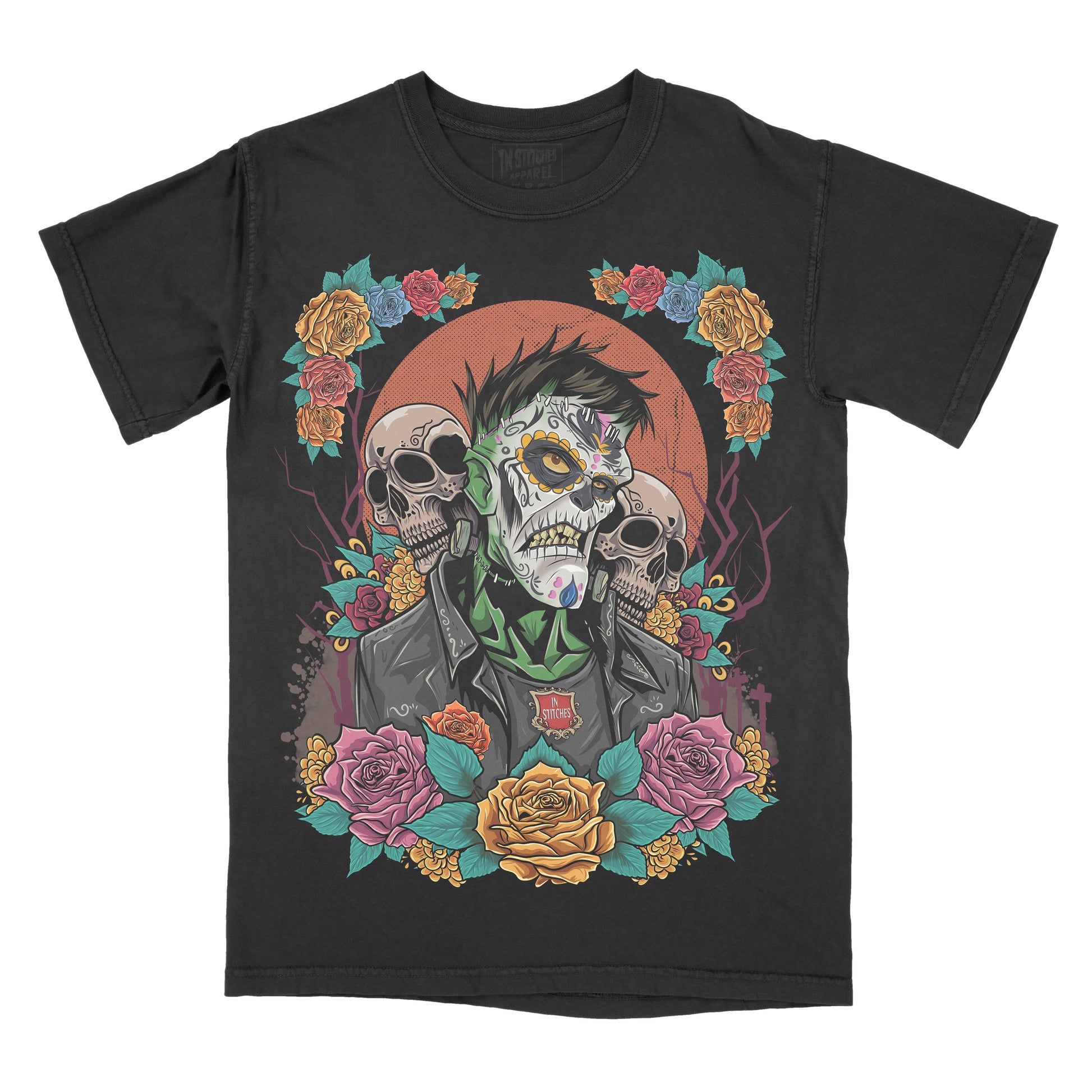 Black garment-dyed graphic t-shirt featuring an original Frankenstein-inspired Day of the Dead design with sugar skull details, colorful floral artwork, and gothic horror aesthetics.