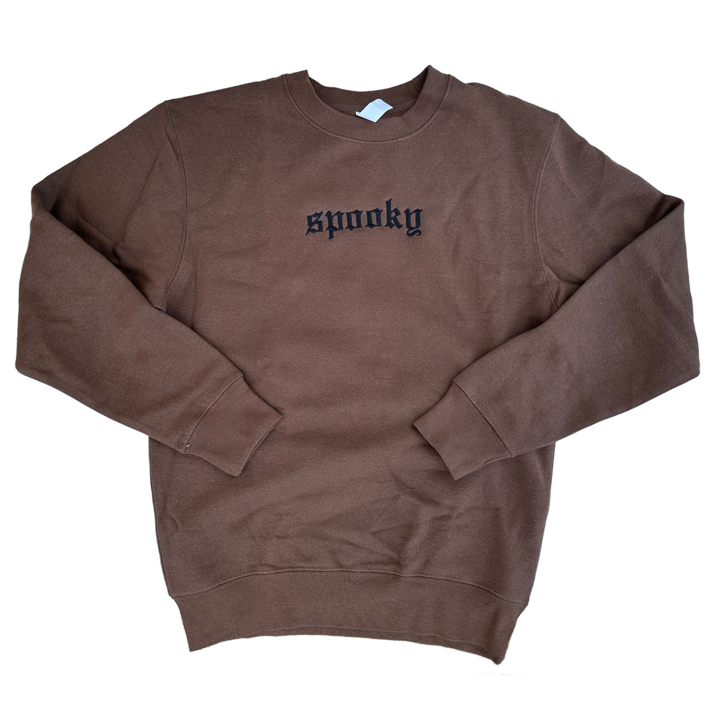 Brown crewneck sweatshirt featuring black embroidered Old English text across the chest that reads “spooky,” shown on a white background.