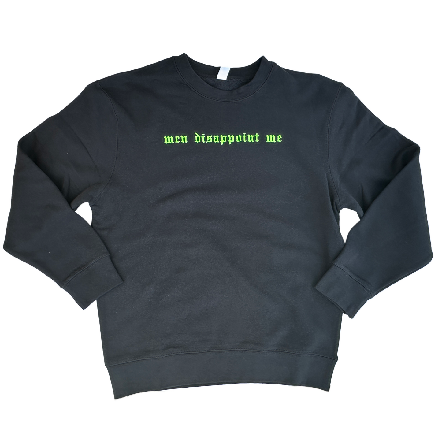Black crewneck sweatshirt featuring neon green embroidered Old English text across the chest that reads “men disappoint me,” shown on a white background.