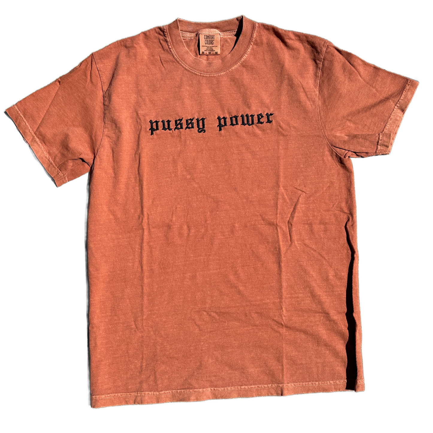 A yam short-sleeve t-shirt with 'pussy power' embroidered in black gothic font across the chest, laid flat against a white background.