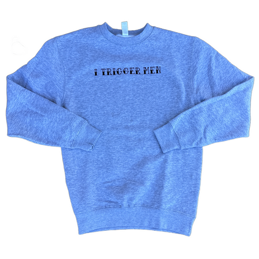 A heather grey crewneck sweatshirt with the text 'I TRIGGER MEN' embroidered in black across the chest, laid flat on a white background.