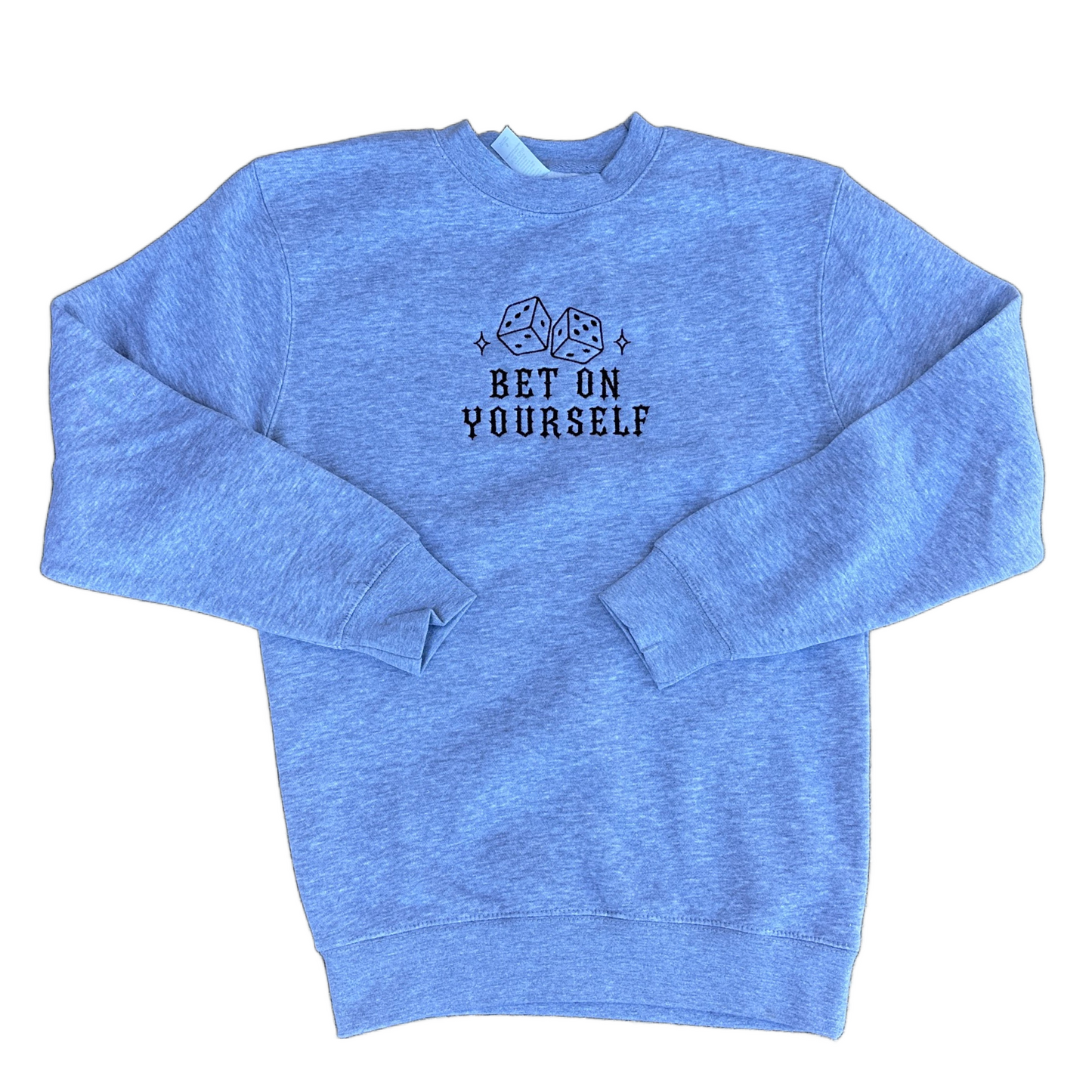 A grey crewneck sweatshirt with a black graphic of two dice and the text 'BET ON YOURSELF' embroidered on the chest, displayed flat against a white background.