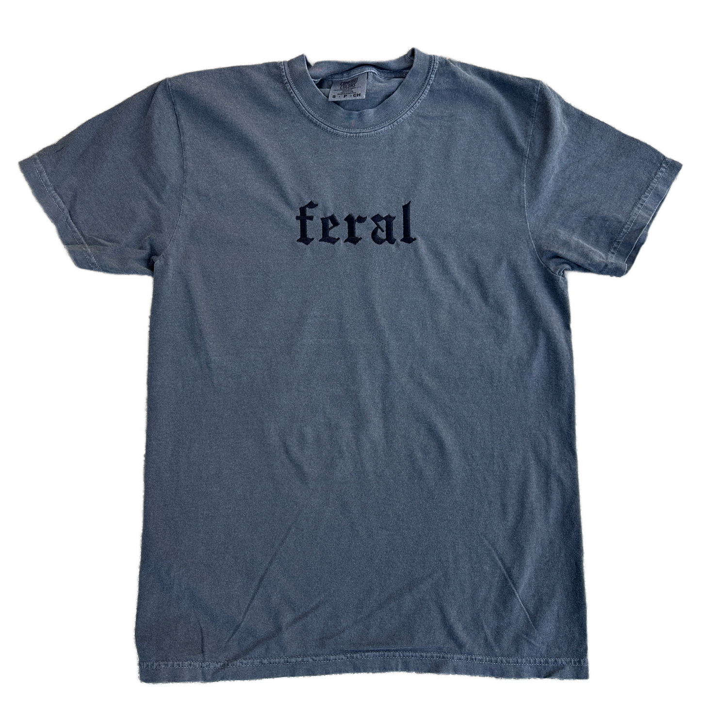 A pepper embroidered t-shirt with the word 'feral' written in bold letters across the front.