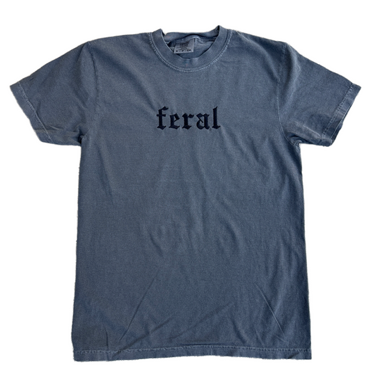 A pepper embroidered t-shirt with the word 'feral' written in bold letters across the front.
