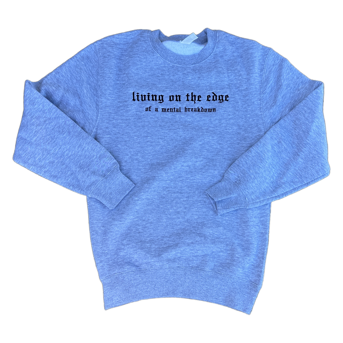 A heather gray crewneck sweatshirt with black gothic text reading 'living on the edge of a mental breakdown' across the chest, displayed flat against a white background.