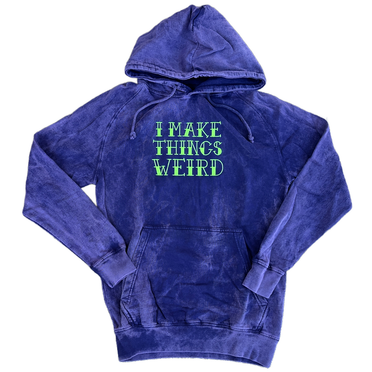Purple mineral-washed hoodie featuring bright neon green embroidered text across the chest that reads “I MAKE THINGS WEIRD,” with a drawstring hood and front kangaroo pocket.