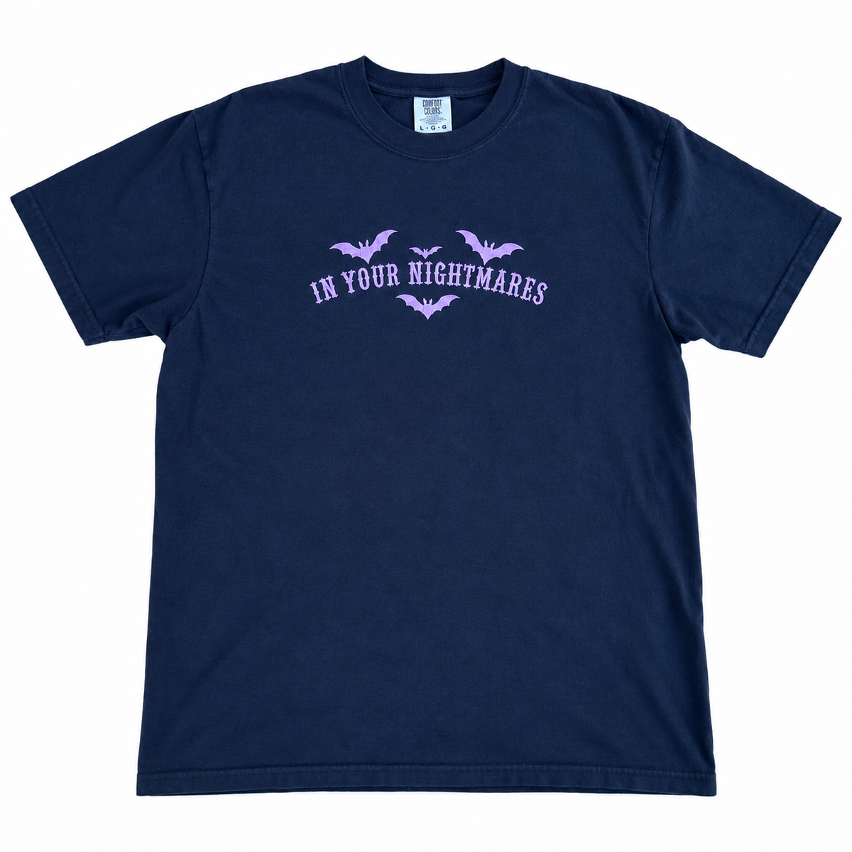 black Comfort Colors T-shirt featuring lavender embroidered gothic text reading “In Your Nightmares,” surrounded by four embroidered bats, styled on a white  background.
