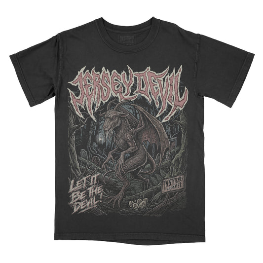 A black short-sleeve graphic t-shirt featuring the Jersey Devil. The front has a large graphic print of a devil creature in a dark forest, with the name 'JERSEY DEVIL' in a stylized font across the chest and the text 'LET IT BE THE DEVIL' on the lower left.