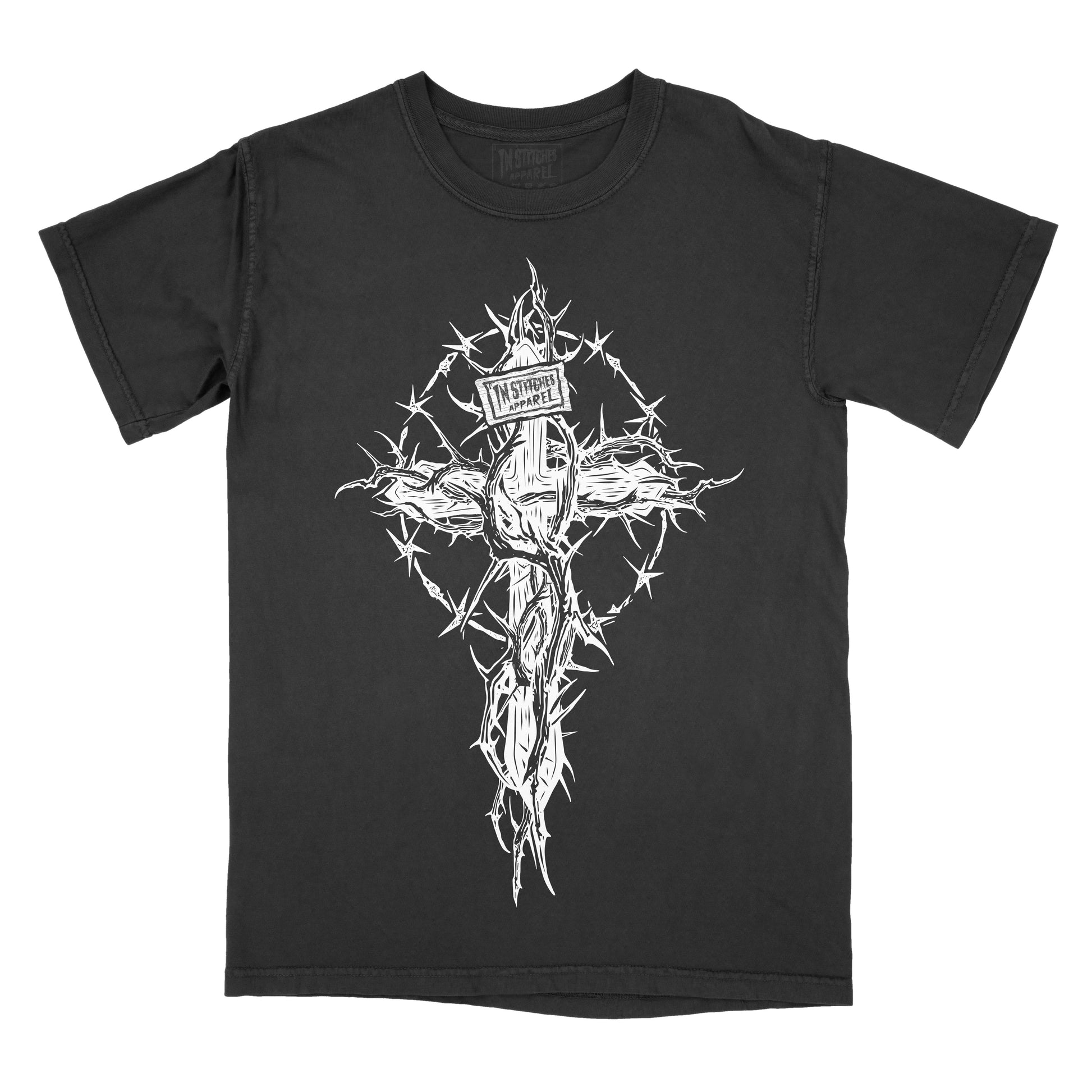 Black T-shirt featuring a white thorn-covered wooden cross surrounded by a circular crown of thorns. A small sign reading "In Stitches Apparel" is nailed to the top of the cross.