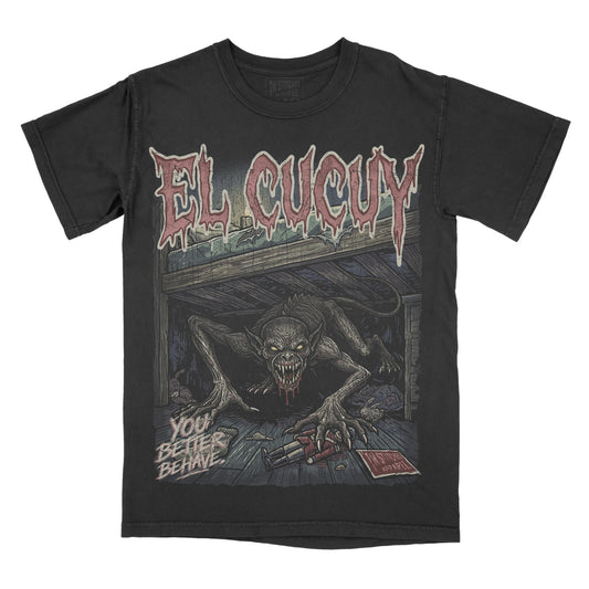 A black short-sleeve graphic t-shirt featuring the El Cucuy with a large horror illustration of a creature in a dark room and the text 'YOU BETTER BEHAVE'.