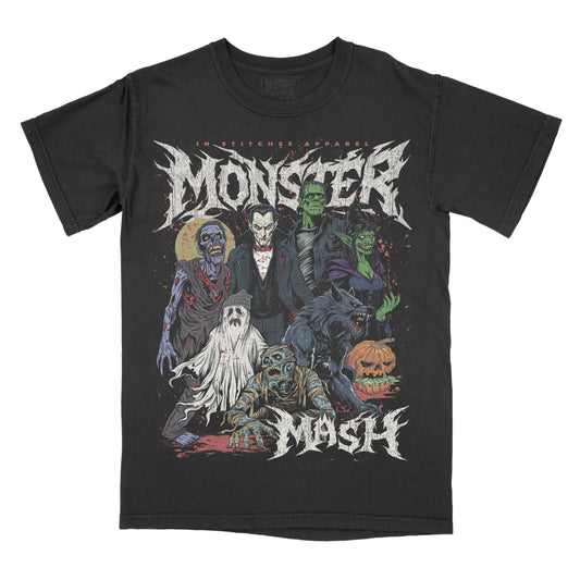 Black vintage-style t-shirt featuring bold gothic lettering that reads ‘Monster Mash.’ The design shows a group of classic horror characters including a zombie, vampire, Frankenstein’s monster, witch, ghost, mummy, werewolf, and a carved jack-o’-lantern. The artwork uses muted tones with green, purple, orange, and red accents in a distressed, horror-themed illustration. ‘In Stitches Apparel’ branding appears above the design.