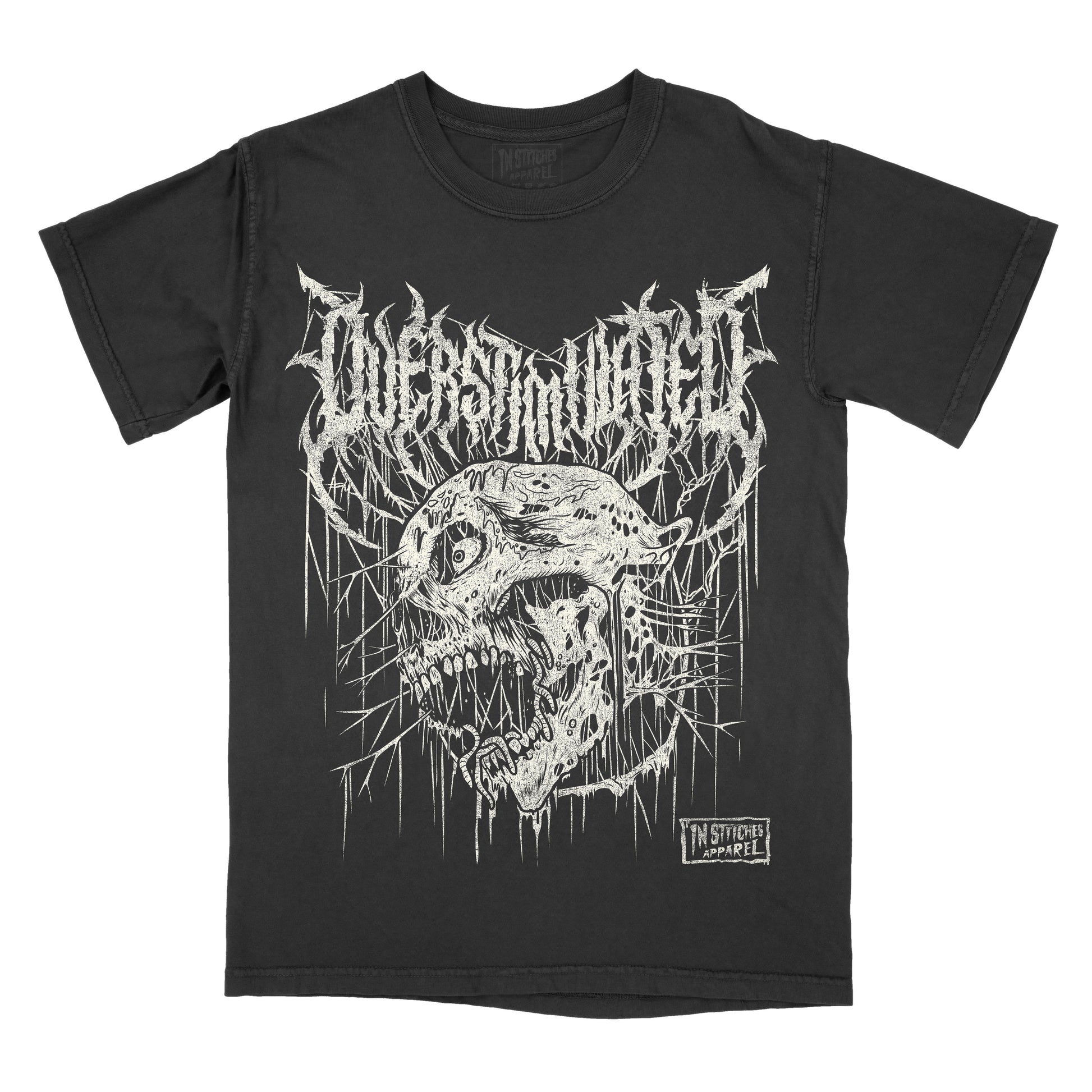 A black short-sleeve graphic t-shirt featuring a white distressed metal logo that reads 'overstimulated' above a detailed white skull illustration with dripping paint effects. A small 'In Stitches Apparel' brand label is visible on the lower right of the graphic.