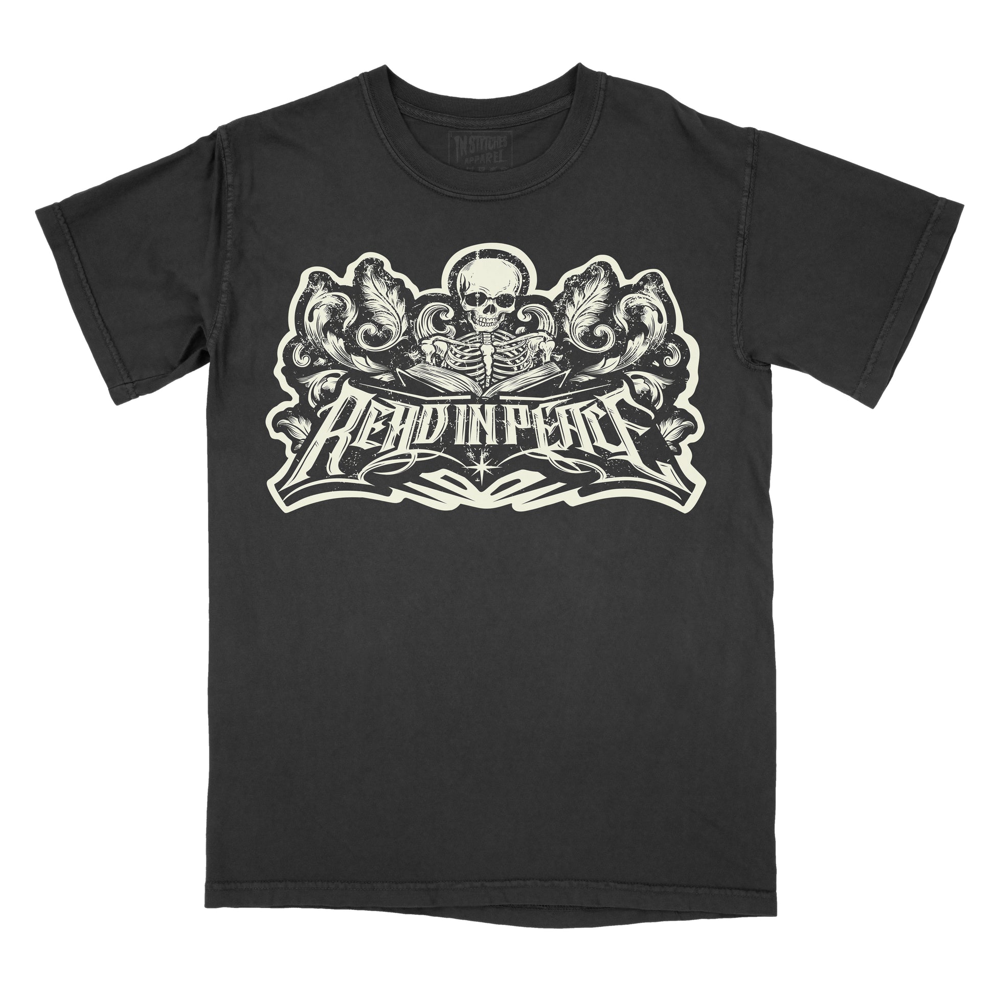 A black short-sleeve t-shirt with a large cream-colored graphic on the front featuring a skull, ornate scrollwork, and the text 'READ IN PEACE'.