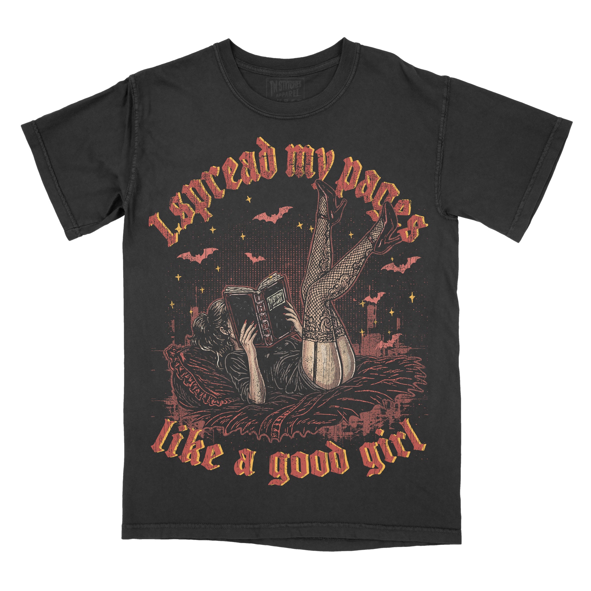 Black Comfort Colors graphic T-shirt featuring a woman reading a book on a bed with the phrase "I spread my pages like a good girl" in vintage gothic lettering, surrounded by bats and stars.