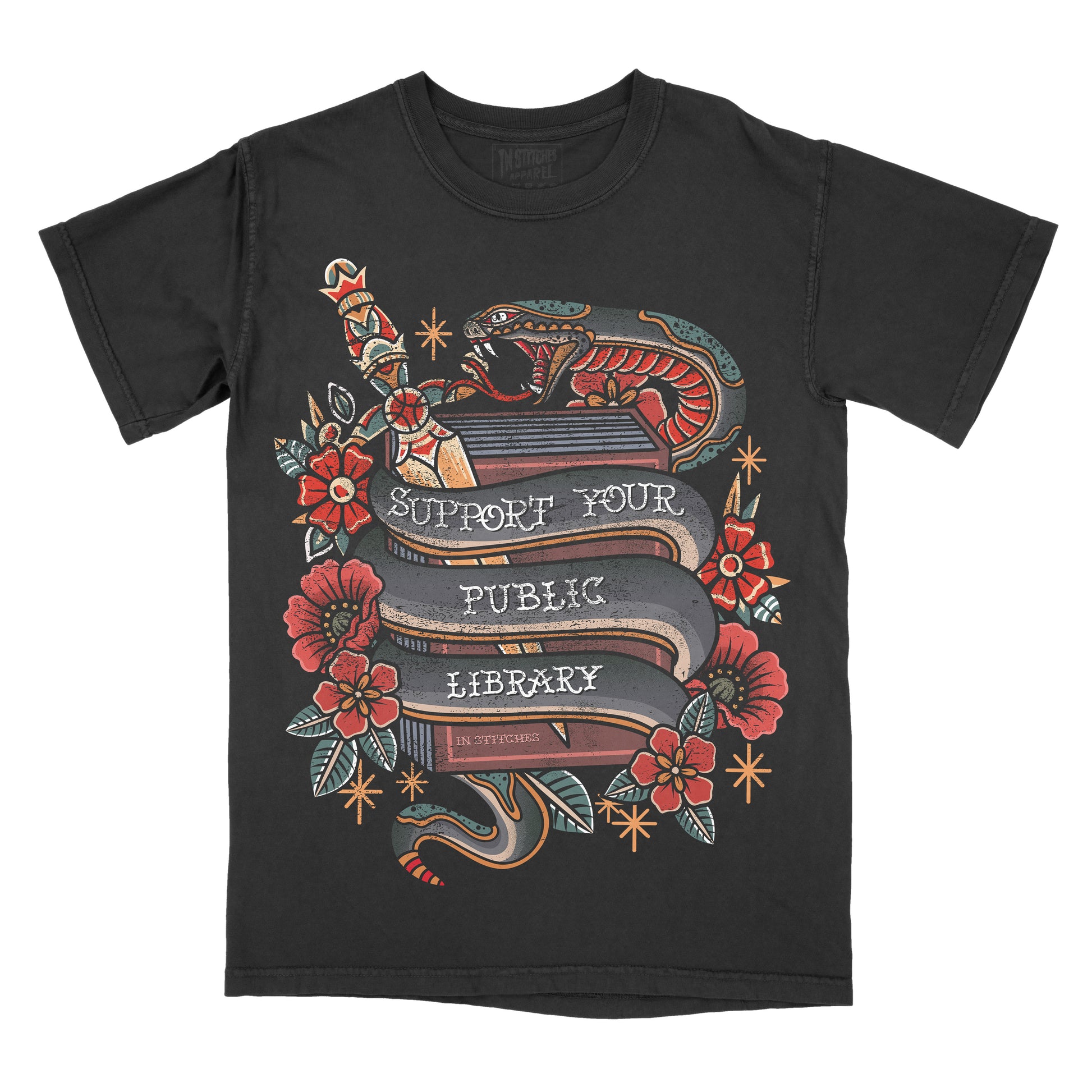 A black short-sleeve crewneck t-shirt featuring a detailed graphic print on the front. The graphic depicts a traditional tattoo-style design with a snake wrapped around a book, red flowers, and banners reading 'SUPPORT YOUR PUBLIC LIBRARY' 