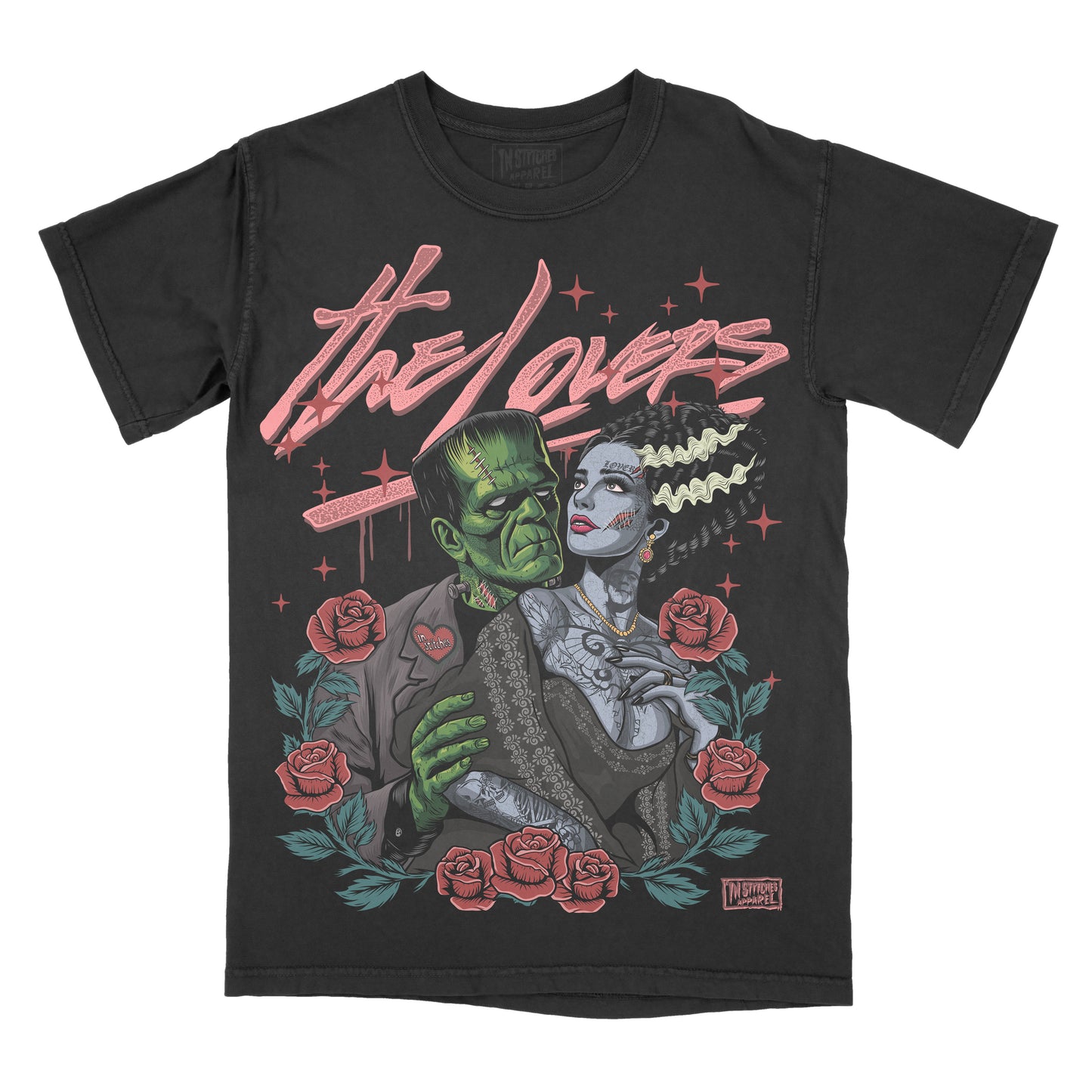 A black short-sleeve graphic t-shirt featuring a retro-style illustration of Frankenstein and The Bride under the text 'the lovers' in pink script, surrounded by red roses and green leaves.